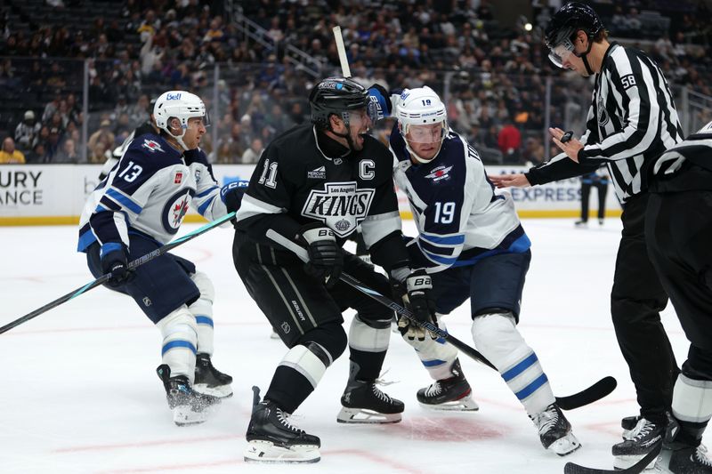 Nov 4, 2025; Los Angeles, California, USA;  Los Angeles Kings center Anze Kopitar (11) and Winnipeg Jets center Jonathan Toews (19) battle for a faceoff during the third period at Crypto.com Arena. Mandatory Credit: Kiyoshi Mio-Imagn Images