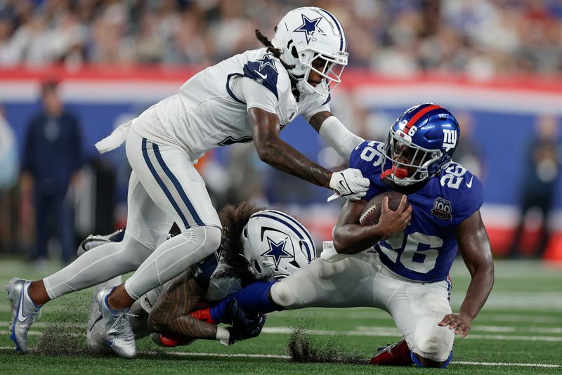 New York Giants running back Devin Singletary (26) is tackled by the Dallas Cowboys during the fourth quarter of an NFL football game, Thursday, Sept. 26, 2024, in East Rutherford, N.J. (AP Photo/Adam Hunger)