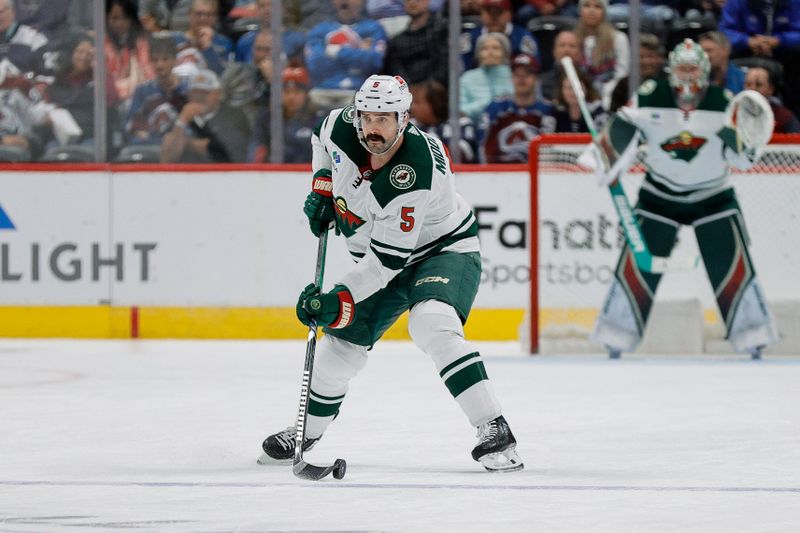 Apr 9, 2024; Denver, Colorado, USA; Minnesota Wild defenseman Jake Middleton (5) controls the puck in the third period against the Colorado Avalanche at Ball Arena. Mandatory Credit: Isaiah J. Downing-USA TODAY Sports