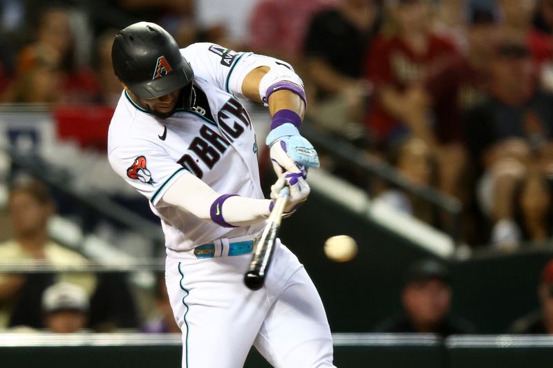 Oct 11, 2023; Phoenix, Arizona, USA; Arizona Diamondbacks left fielder Lourdes Gurriel Jr. (12) hits a single against the Los Angeles Dodgers in the second inning for game three of the NLDS for the 2023 MLB playoffs at Chase Field. Mandatory Credit: Mark J. Rebilas-USA TODAY Sports