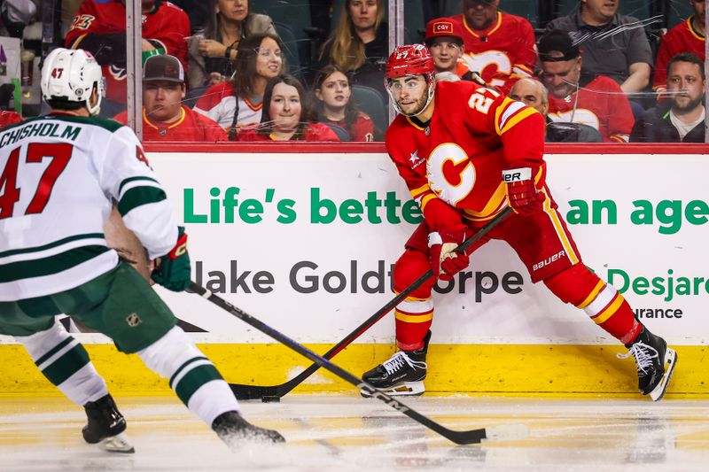 Apr 11, 2025; Calgary, Alberta, CAN; Calgary Flames right wing Matt Coronato (27) controls the puck against Minnesota Wild defenseman Declan Chisholm (47) during the second period at Scotiabank Saddledome. Mandatory Credit: Sergei Belski-Imagn Images