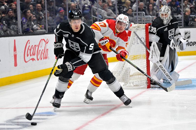 Apr 11, 2024; Los Angeles, California, USA; Los Angeles Kings defenseman Andreas Englund (5) keeps the puck from Calgary Flames center Yegor Sharangovich (17) in the third period at Crypto.com Arena. Mandatory Credit: Jayne Kamin-Oncea-USA TODAY Sports