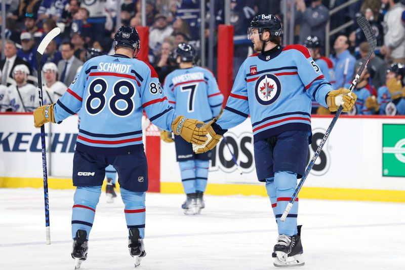 Jan 27, 2024; Winnipeg, Manitoba, CAN; Winnipeg Jets defenseman Dylan Samberg (54) celebrates his first period goal with Winnipeg Jets defenseman Nate Schmidt (88) against the Toronto Maple Leafs at Canada Life Centre. Mandatory Credit: James Carey Lauder-USA TODAY Sports