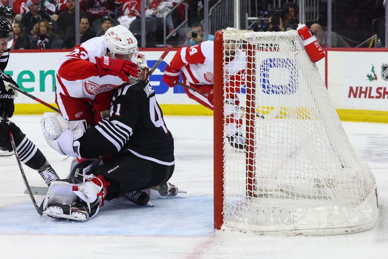 Dec 23, 2023; Newark, New Jersey, USA; Detroit Red Wings left wing Lucas Raymond (23) collides with New Jersey Devils goaltender Vitek Vanecek (41) during the third period at Prudential Center. Mandatory Credit: Ed Mulholland-USA TODAY Sports