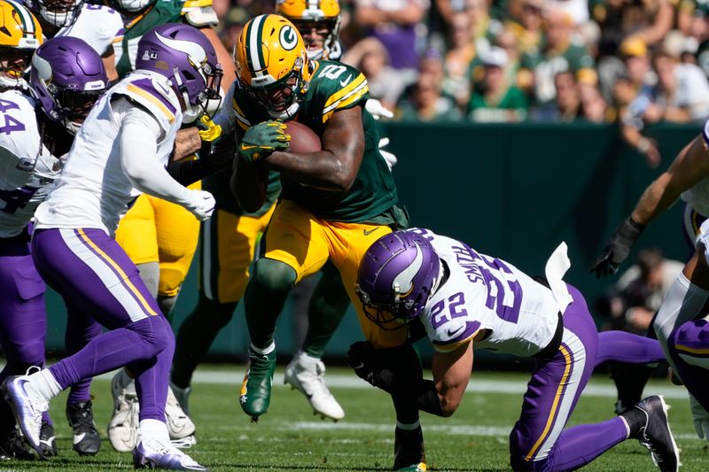 Green Bay Packers running back Josh Jacobs (8) runs the ball as he is tackled by Minnesota Vikings safety Harrison Smith (22) during the first half of an NFL football game Sunday, Sept. 29, 2024, in Green Bay, Wis. (AP Photo/Morry Gash)