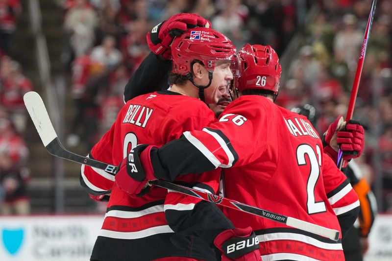 Oct 30, 2025; Raleigh, North Carolina, USA;  Carolina Hurricanes defenseman Mike Reilly (6) celebrates his goal witb center Seth Jarvis (24) and  defenseman Sean Walker (26) against the New York Islanders during the first period at Lenovo Center. Mandatory Credit: James Guillory-Imagn Images