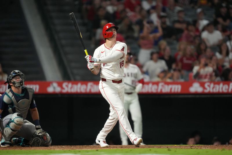 Aug 31, 2024; Anaheim, California, USA; Los Angeles Angels center fielder Mickey Moniak (16) hits a walk-off home run in the ninth inning as Seattle Mariners catcher Cal Raleigh (29) watches at Angel Stadium. Mandatory Credit: Kirby Lee-USA TODAY Sports