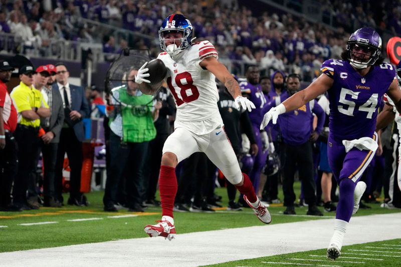 New York Giants wide receiver Isaiah Hodgins (18) runs from Minnesota Vikings linebacker Eric Kendricks (54) after catching a pass during second half of an NFL wild card playoff football game, Sunday, Jan. 15, 2023, in Minneapolis. (AP Photo/Charlie Neibergall)