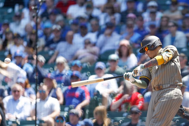 May 8, 2024; Chicago, Illinois, USA; San Diego Padres third baseman Manny Machado (13) hits an RBI-single against the Chicago Cubs during the first inning at Wrigley Field. Mandatory Credit: Kamil Krzaczynski-USA TODAY Sports