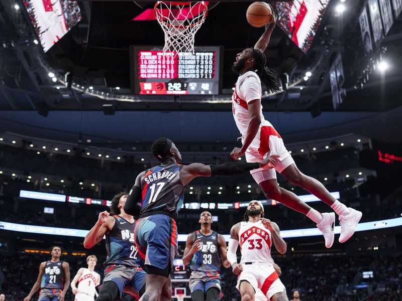 TORONTO, ON - MARCH 25: Javon Freeman-Liberty #0 of the Toronto Raptors dunks against Dennis Schroder #17 of the Brooklyn Nets during the first half of their basketball game at the Scotiabank Arena on March 25, 2024 in Toronto, Ontario, Canada. NOTE TO USER: User expressly acknowledges and agrees that, by downloading and/or using this Photograph, user is consenting to the terms and conditions of the Getty Images License Agreement. (Photo by Mark Blinch/Getty Images)