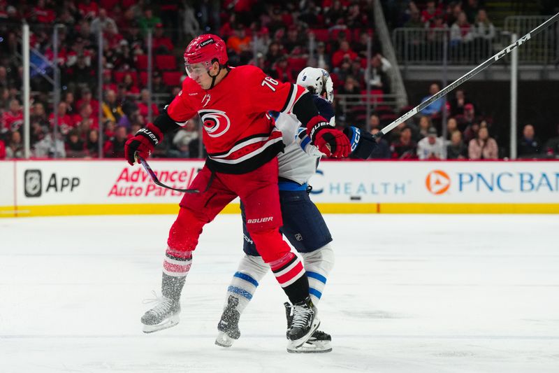 Mar 2, 2024; Raleigh, North Carolina, USA; Carolina Hurricanes defenseman Brady Skjei (76) checks Winnipeg Jets left wing Alex Iafallo (9) during the second period at PNC Arena. Mandatory Credit: James Guillory-USA TODAY Sports