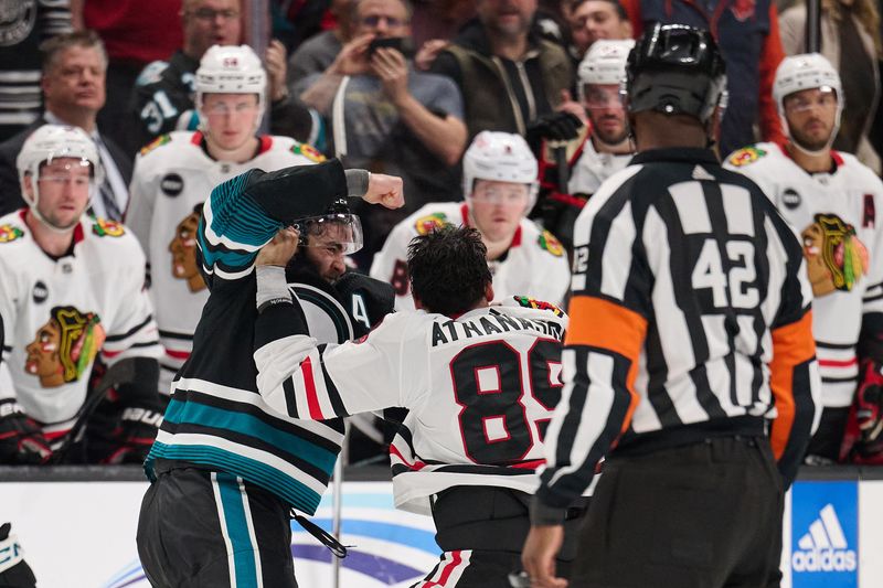 Mar 23, 2024; San Jose, California, USA; San Jose Sharks center Luke Kunin (11) fights against Chicago Blackhawks center Andreas Athanasiou (89) during the first period at SAP Center at San Jose. Mandatory Credit: Robert Edwards-USA TODAY Sports