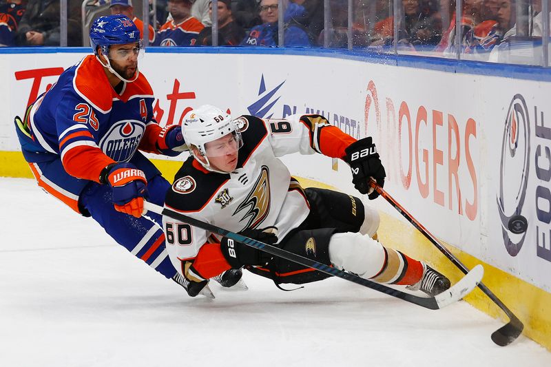 Nov 26, 2023; Edmonton, Alberta, CAN; Edmonton Oilers defensemen Darnell Nurse (25) trips up Anaheim Ducks defensemen Jackson LaCombe (60) while chasing a loose puck during the second period at Rogers Place. Mandatory Credit: Perry Nelson-USA TODAY Sports