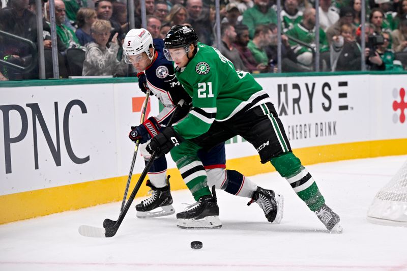 Oct 21, 2025; Dallas, Texas, USA; Columbus Blue Jackets defenseman Denton Mateychuk (5) and Dallas Stars left wing Jason Robertson (21) battle for control of the puck during the second period at the American Airlines Center. Mandatory Credit: Jerome Miron-Imagn Images