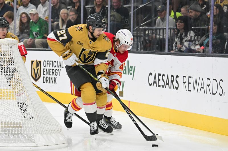 Oct 28, 2024; Las Vegas, Nevada, USA; Vegas Golden Knights defenseman Shea Theodore (27) battles for the puck with Calgary Flames center Connor Zary (47) in the first period at T-Mobile Arena. Mandatory Credit: Candice Ward-Imagn Images