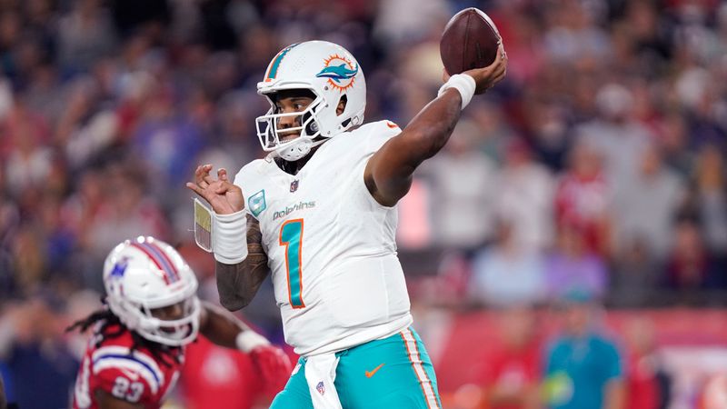 Miami Dolphins quarterback Tua Tagovailoa (1) throws while pressured by New England Patriots safety Kyle Dugger (23) during the first half of an NFL football game, Sunday, Sept. 17, 2023, in Foxborough, Mass. (AP Photo/Steven Senne)