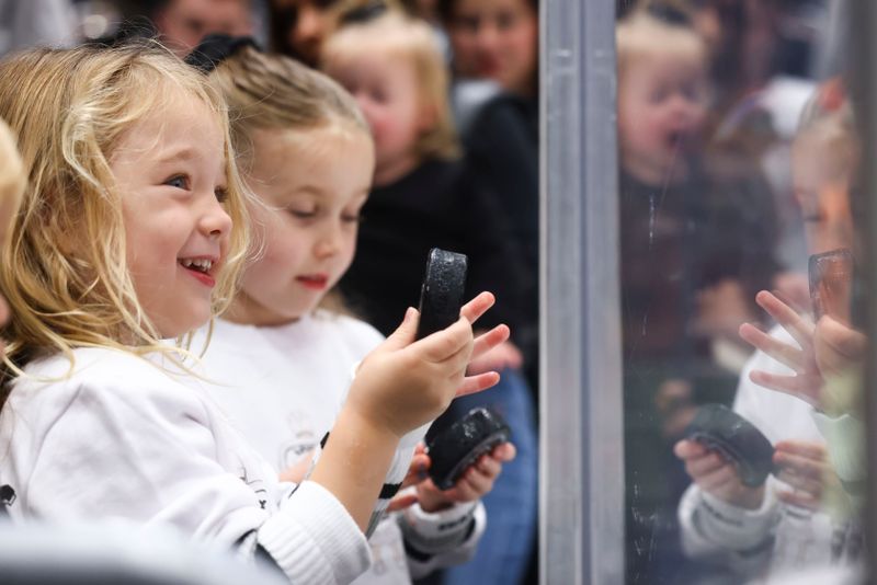 Dec 23, 2023; Los Angeles, California, USA; An Los Angeles Kings fan reacts after receiving a puck before a game against the Calgary Flames at Crypto.com Arena. Mandatory Credit: Jessica Alcheh-USA TODAY Sports