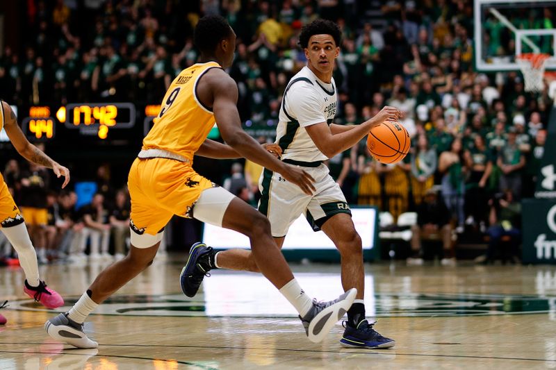 Feb 15, 2025; Fort Collins, Colorado, USA; Colorado State Rams guard Jalen Lake (15) controls the ball as Wyoming Cowboys forward Abou Magassa (9) guards in the second half at Moby Arena. Mandatory Credit: Isaiah J. Downing-Imagn Images