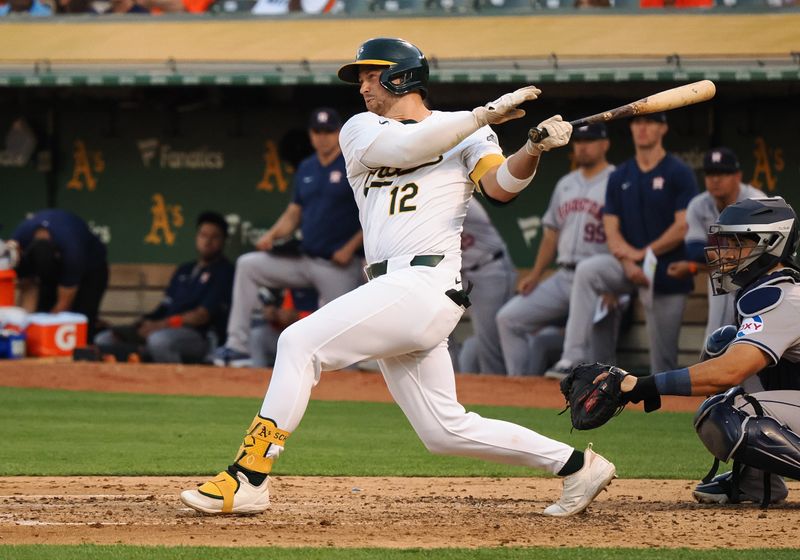Jul 22, 2024; Oakland, California, USA; Oakland Athletics shortstop Max Shuemann (12) hits an RBI single against the Houston Astros during the fourth inning at Oakland-Alameda County Coliseum. Mandatory Credit: Kelley L Cox-USA TODAY Sports