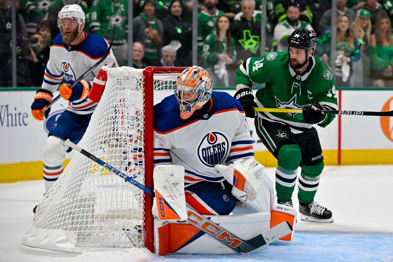 May 23, 2024; Dallas, Texas, USA; Edmonton Oilers goaltender Stuart Skinner (74) and Dallas Stars left wing Jamie Benn (14) look for the puck during the overtime period in game one of the Western Conference Final of the 2024 Stanley Cup Playoffs at American Airlines Center. Mandatory Credit: Jerome Miron-USA TODAY Sports