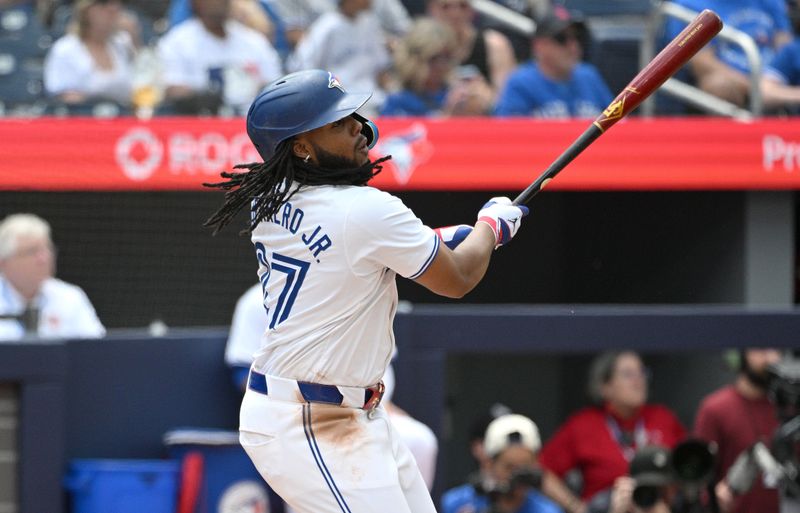 Jun 6, 2024; Toronto, Ontario, CAN;   Toronto Blue Jays first baseman Vladimir Guerrero Jr. (27) hits a single in the fifth inning against the Baltimore Orioles at Rogers Centre. Mandatory Credit: Dan Hamilton-USA TODAY Sports