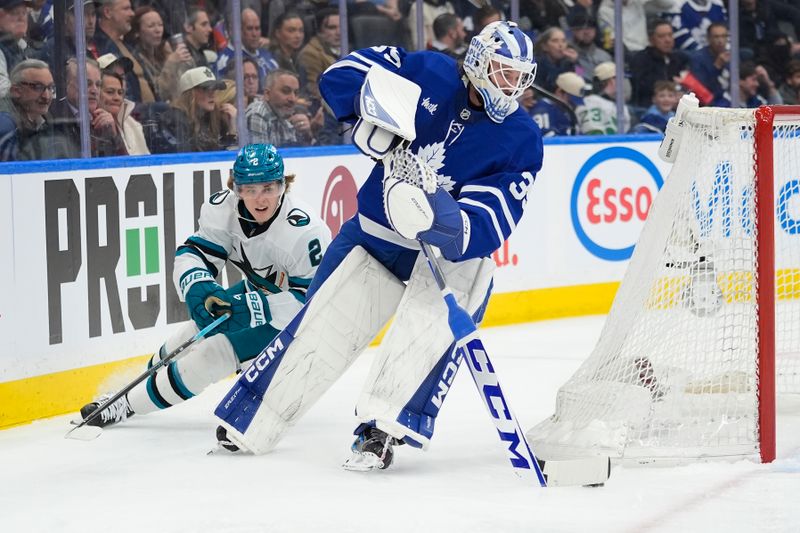 Dec 11, 2025; Toronto, Ontario, CAN; Toronto Maple Leafs goaltender Dennis Hildeby (35) carries the puck as San Jose Sharks forward Will Smith (2) pursues during the second period at Scotiabank Arena. Mandatory Credit: John E. Sokolowski-Imagn Images