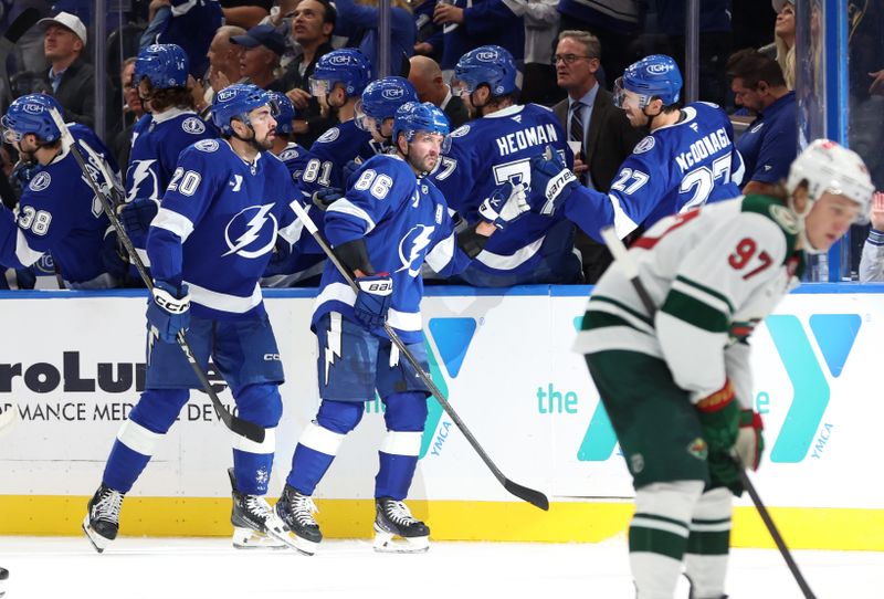 Oct 24, 2024; Tampa, Florida, USA; Tampa Bay Lightning right wing Nikita Kucherov (86) is congratulated by teammates after he scored a goal against the Minnesota Wild during the second period at Amalie Arena. Mandatory Credit: Kim Klement Neitzel-Imagn Images