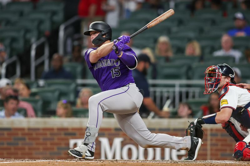 Sep 3, 2024; Atlanta, Georgia, USA; Colorado Rockies right fielder Hunter Goodman (15) hits a single against the Atlanta Braves in the seventh inning at Truist Park. Mandatory Credit: Brett Davis-Imagn Images 