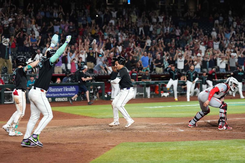 May 13, 2024; Phoenix, Arizona, USA; Arizona Diamondbacks catcher Gabriel Moreno (14) celebrates after scoring the game winning run against the Cincinnati Reds during the ninth inning at Chase Field. Mandatory Credit: Joe Camporeale-USA TODAY Sports