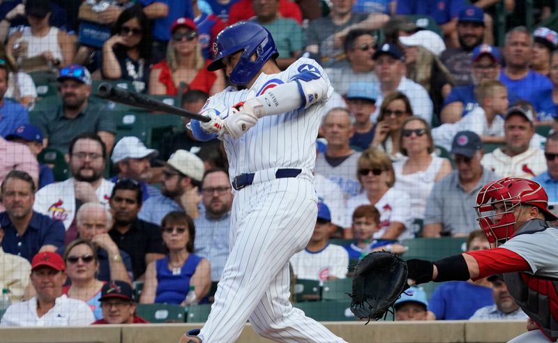 Aug 4, 2024; Chicago, Illinois, USA; Chicago Cubs outfielder Seiya Suzuki (27) hits a single against the St. Louis Cardinals during the first inning at Wrigley Field. Mandatory Credit: David Banks-USA TODAY Sports