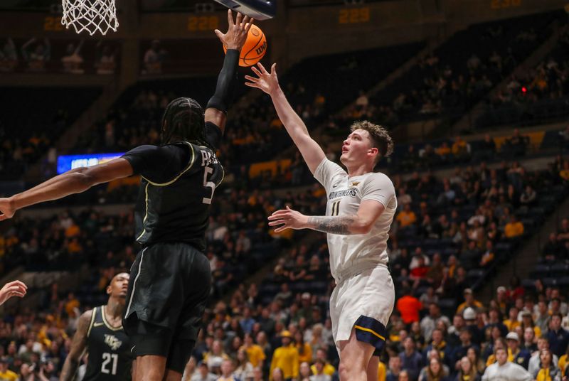 Feb 20, 2024; Morgantown, West Virginia, USA; West Virginia Mountaineers forward Quinn Slazinski (11) shoots over UCF Knights forward Omar Payne (5) during the second half at WVU Coliseum. Mandatory Credit: Ben Queen-USA TODAY Sports