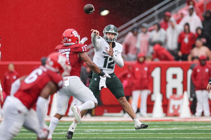 Oct 14, 2023; Piscataway, New Jersey, USA; Michigan State Spartans quarterback Katin Houser (12) throws the ball as Rutgers Scarlet Knights linebacker Deion Jennings (17) defends during the second half at SHI Stadium. Mandatory Credit: Vincent Carchietta-USA TODAY Sports