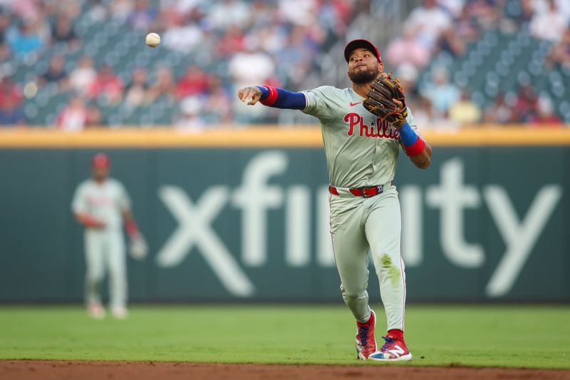 Aug 21, 2024; Atlanta, Georgia, USA; Philadelphia Phillies second baseman Edmundo Sosa (33) attempts to throw a runner out at first against the Atlanta Braves in the first inning at Truist Park. Mandatory Credit: Brett Davis-USA TODAY Sports