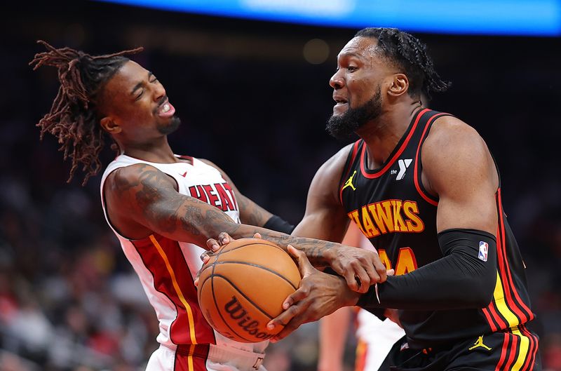 ATLANTA, GEORGIA - APRIL 09:  Bruno Fernando #24 of the Atlanta Hawks draws a foul as he drives against Delon Wright #4 of the Miami Heat during the third quarter at State Farm Arena on April 09, 2024 in Atlanta, Georgia.  NOTE TO USER: User expressly acknowledges and agrees that, by downloading and/or using this photograph, user is consenting to the terms and conditions of the Getty Images License Agreement.  (Photo by Kevin C. Cox/Getty Images)