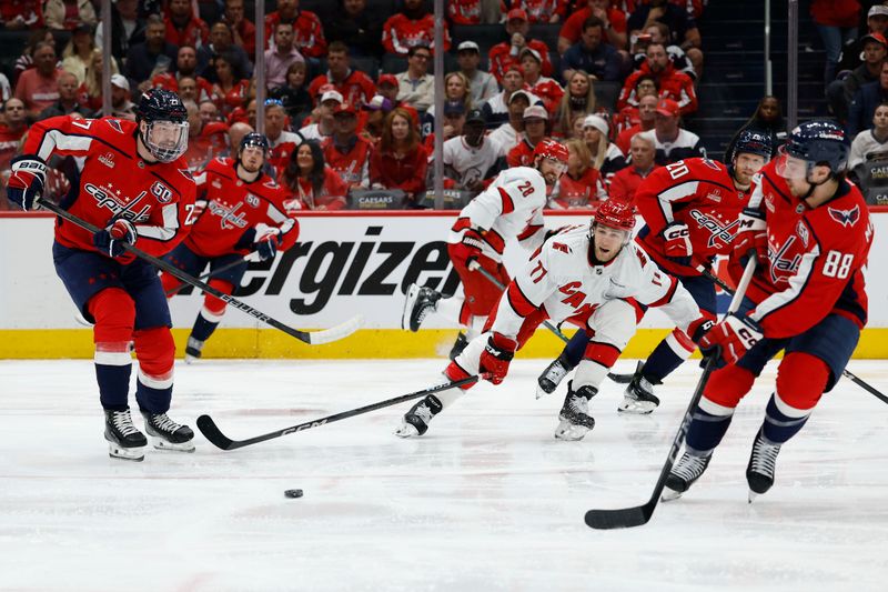 May 6, 2025; Washington, District of Columbia, USA; Washington Capitals defenseman Alexander Alexeyev (27) passes the puck to Capitals left wing Andrew Mangiapane (88) as Carolina Hurricanes center Mark Jankowski (77) defends in the second period in game one of the second round of the 2025 Stanley Cup Playoffs at Capital One Arena. Mandatory Credit: Geoff Burke-Imagn Images