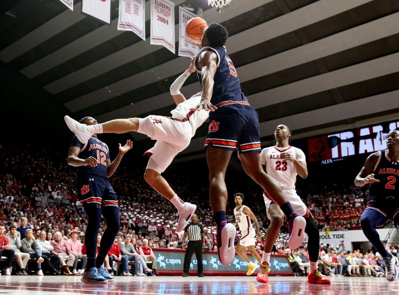 Jan 24, 2024; Tuscaloosa, Alabama, USA;  Alabama Crimson tideguard Mark Sears (1) makes an acrobatic shot in the lane with Auburn Tigers forward Chris Moore (5) defending at Coleman Coliseum. Mandatory Credit: Gary Cosby Jr.-USA TODAY Sports