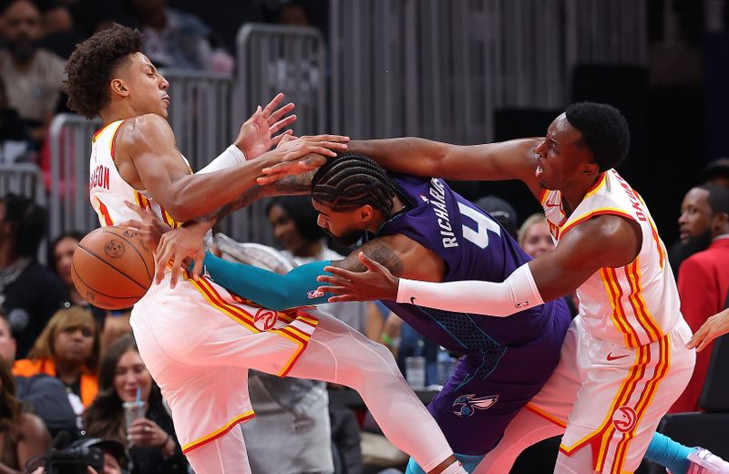 ATLANTA, GEORGIA - OCTOBER 25:  Nick Richards #4 of the Charlotte Hornets draws a foul as his shot is blocked by Jalen Johnson #1 and Onyeka Okongwu #17 of the Atlanta Hawks during the third quarter at State Farm Arena on October 25, 2024 in Atlanta, Georgia.  NOTE TO USER: User expressly acknowledges and agrees that, by downloading and/or using this photograph, user is consenting to the terms and conditions of the Getty Images License Agreement.  (Photo by Kevin C. Cox/Getty Images)