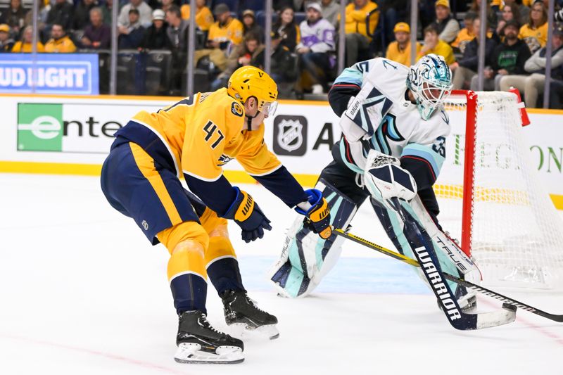 Oct 15, 2024; Nashville, Tennessee, USA;  Seattle Kraken goaltender Joey Daccord (35) clears the puck past Nashville Predators right wing Michael McCarron (47) during the first period at Bridgestone Arena. Mandatory Credit: Steve Roberts-Imagn Images