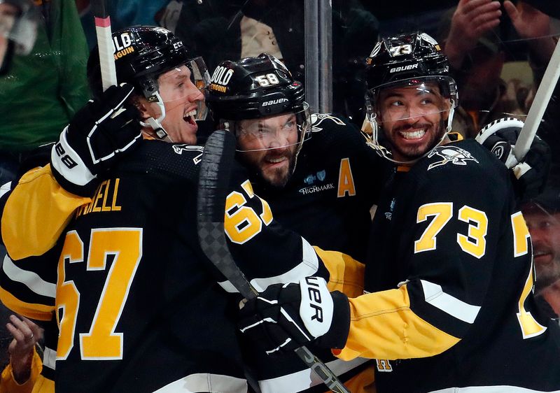 Apr 11, 2024; Pittsburgh, Pennsylvania, USA; Pittsburgh Penguins right wing Rickard Rakell (67) and defenseman Pierre-Olivier Joseph (73) congratulate defenseman Kris Letang (middle) on his goal against the Detroit Red Wings during the first period at PPG Paints Arena. Mandatory Credit: Charles LeClaire-USA TODAY Sports