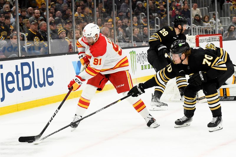 Feb 6, 2024; Boston, Massachusetts, USA; Calgary Flames center Nazem Kadri (91) controls the puck away from Boston Bruins center Jesper Boqvist (70) during the second period at TD Garden. Mandatory Credit: Bob DeChiara-USA TODAY Sports