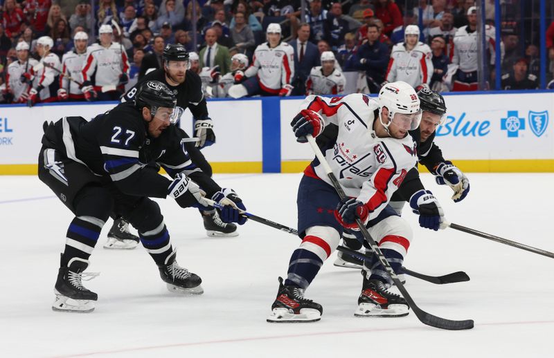 Oct 26, 2024; Tampa, Florida, USA; Tampa Bay Lightning center Zemgus Girgensons (28) and defenseman Ryan McDonagh (27) defend Washington Capitals left wing Andrew Mangiapane (88) during the second period at Amalie Arena. Mandatory Credit: Kim Klement Neitzel-Imagn Images