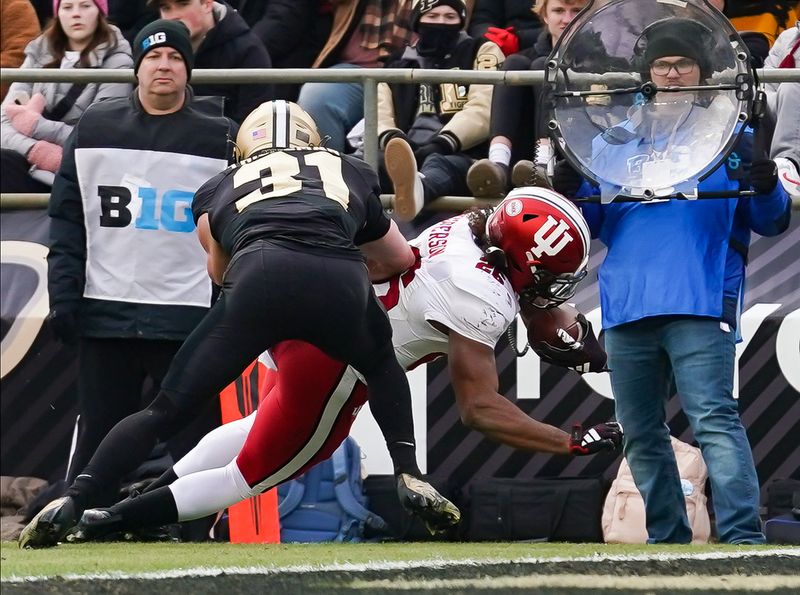 Nov 25, 2023; West Lafayette, Indiana, USA;  Indiana Hoosiers running back Josh Henderson (26) runs for a touchdown against Purdue Boilermakers defensive back Dillon Thieneman (31) during the second half at Ross-Ade Stadium. Mandatory Credit: Robert Goddin-USA TODAY Sports