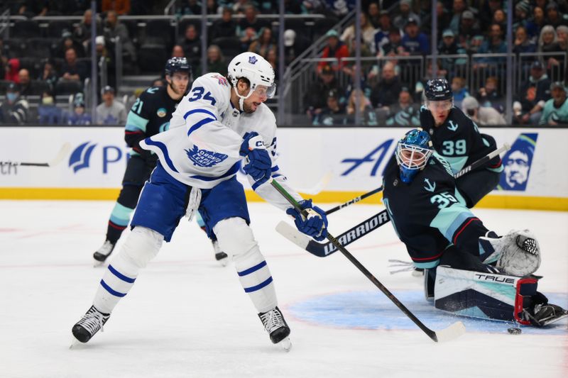 Jan 21, 2024; Seattle, Washington, USA; Toronto Maple Leafs center Auston Matthews (34) scores a goal past Seattle Kraken goaltender Joey Daccord (35) during the first period at Climate Pledge Arena. Mandatory Credit: Steven Bisig-USA TODAY Sports