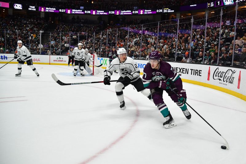 Nov 24, 2023; Anaheim, California, USA; Anaheim Ducks right wing Frank Vatrano (77) moves the puck against Los Angeles Kings defenseman Jordan Spence (21) during the second period at Honda Center. Mandatory Credit: Gary A. Vasquez-USA TODAY Sports