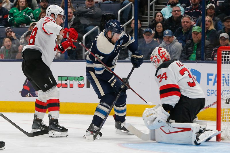 Mar 17, 2025; Columbus, Ohio, USA; New Jersey Devils goalie Jake Allen (34) makes a save on the shot from Columbus Blue Jackets center Mathieu Olivier (24) during the first period at Nationwide Arena. Mandatory Credit: Russell LaBounty-Imagn Images