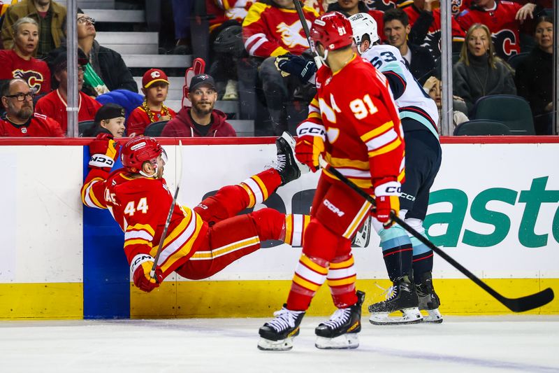 Dec 18, 2025; Calgary, Alberta, CAN; Seattle Kraken right wing Jacob Melanson (63) checks into the boards Calgary Flames defenseman Joel Hanley (44) during the first period at Scotiabank Saddledome. Mandatory Credit: Sergei Belski-Imagn Images