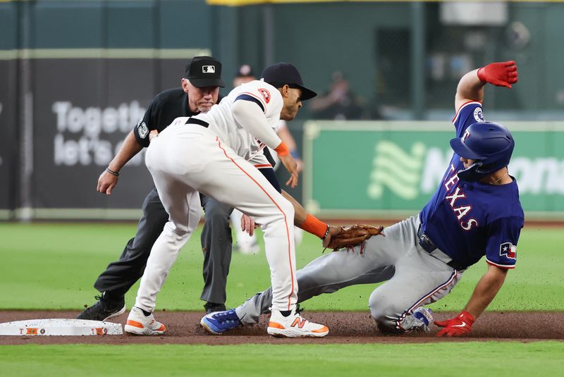 Apr 13, 2024; Houston, Texas, USA;  Texas Rangers designated hitter Wyatt Langford (36) is tagged out by Houston Astros shortstop Jeremy Pena (3) after hitting an RBI single and tying to stretch it out to a double in the first inning at Minute Maid Park. Mandatory Credit: Thomas Shea-USA TODAY Sports