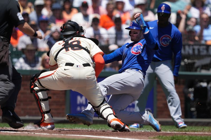 Jun 27, 2024; San Francisco, California, USA; Chicago Cubs designated hitter Ian Happ (center right) is tagged out at home plate by San Francisco Giants catcher Curt Casali (18) during the second inning at Oracle Park. Mandatory Credit: Darren Yamashita-USA TODAY Sports