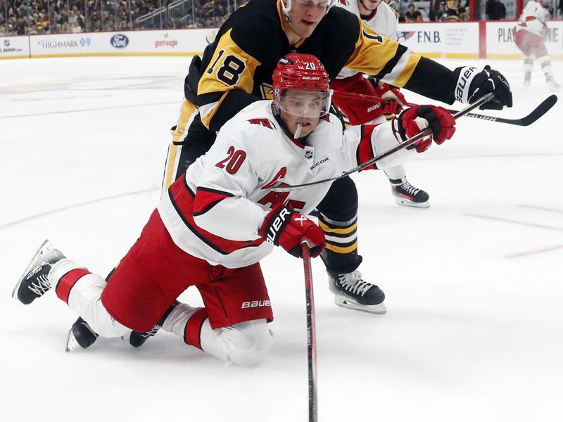 Oct 18, 2024; Pittsburgh, Pennsylvania, USA;  Carolina Hurricanes center Sebastian Aho (20) reaches for the puck against pressure from Pittsburgh Penguins right wing Jesse Puljujarvi (18) during the second period at PPG Paints Arena. Mandatory Credit: Charles LeClaire-Imagn Images