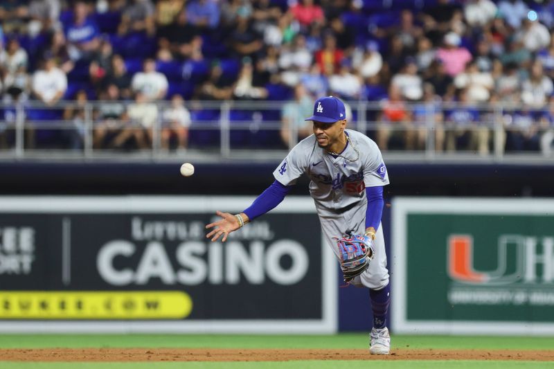 Sep 18, 2024; Miami, Florida, USA; Los Angeles Dodgers shortstop Mookie Betts (50) tosses the baseball to shortstop Tommy Edman (not pictured) to retire Miami Marlins left fielder Kyle Stowers (not pictured) during the fifth inning at loanDepot Park. Mandatory Credit: Sam Navarro-Imagn Images